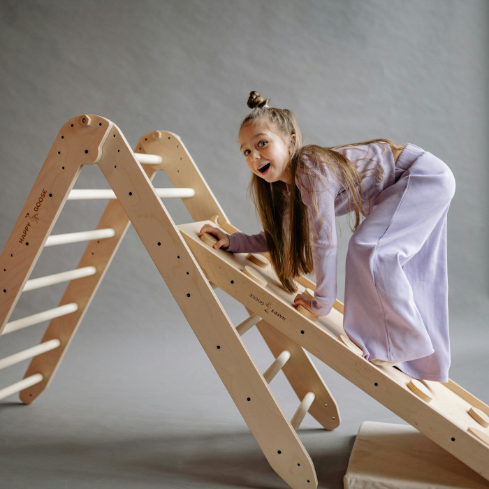 Enfant jouant sur un triangle de Pikler